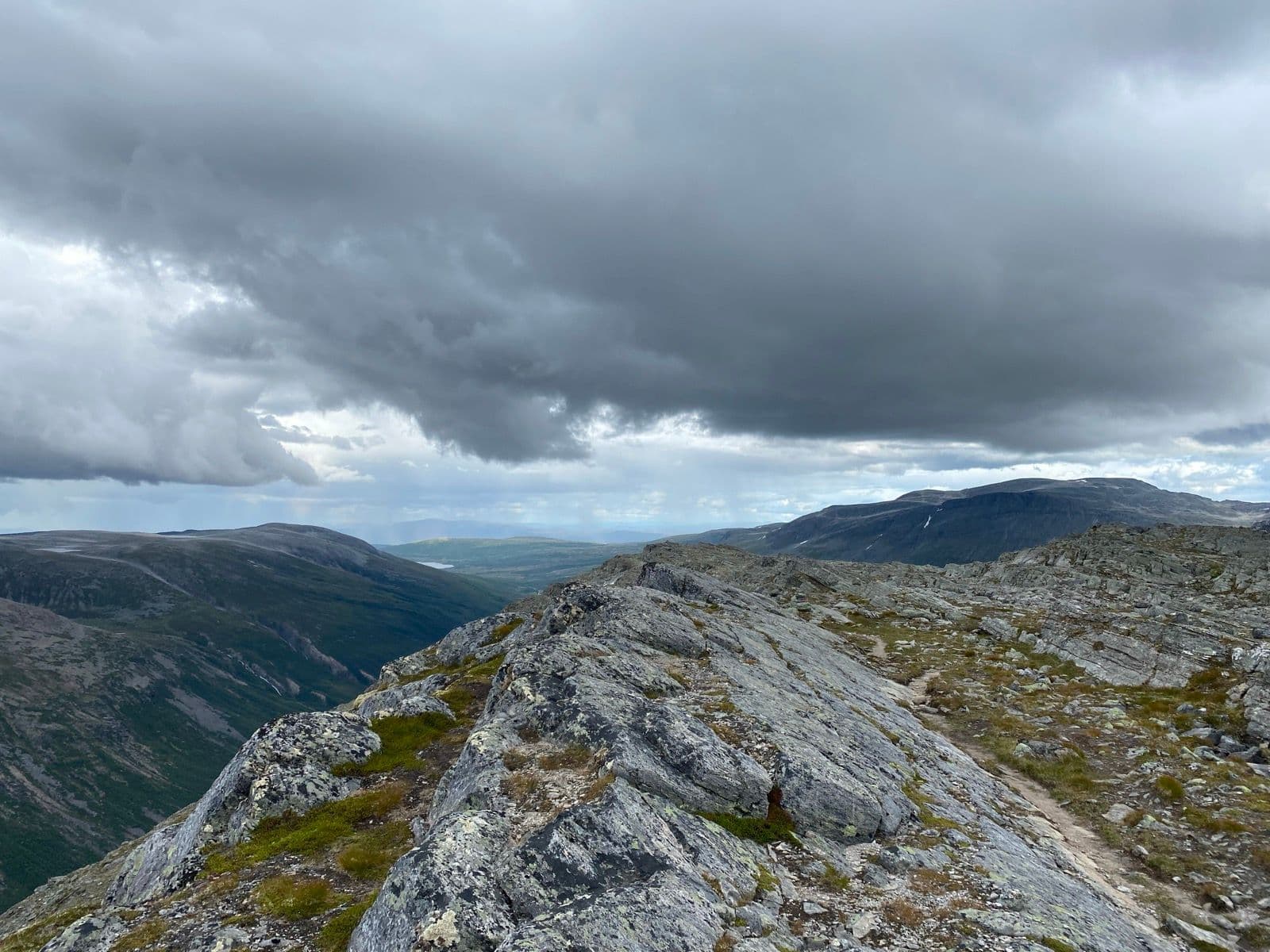 Rocky mountain ridge and valley in Trollheimen under a cloudy sky.