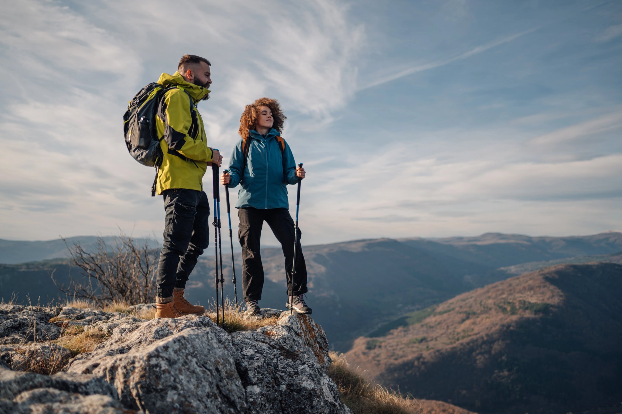 Wandelaars staan op de bergtop en genieten van het uitzicht