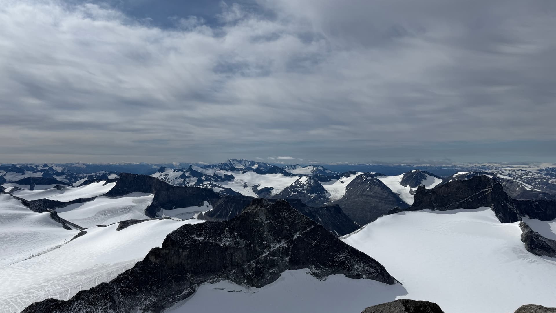 Snowfields of Jotunheimen mountain range under a cloudy sky